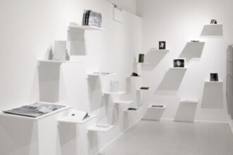 Overview of the nineteen photobook maquettes presented on shelves to mimic a library. Part of the Edition I of the Abysm, at Elysium Gallery, Swansea, UK