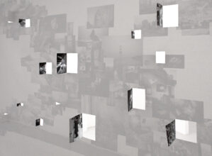 Behind Edition II of the Abysm, where images have been partially cut out of the main image and folded back as pages behind the page. Light shines through the resulting holes, imposing the shape of the page on the floor at Elysium Gallery, Swansea, UK.