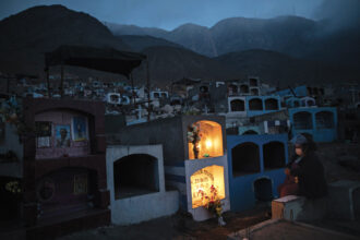 Gladys Ramos sits next to the tomb of her uncle Saturnino Zumia, who died of Covid-19, in Comas, on the outskirts of Lima, Peru, July 21, 2020. At this time, the Pan American Health Organization and other agencies were investigating whether the country failed to classify over 27,000 deaths as caused by coronavirus, a figure that could have more than doubled the country’s official death toll from the disease. Photo by Rodrigo Abd/AP