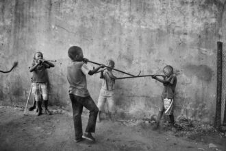 Kids playing with plastic pipes, 2014 © Lindokuhle Sobekwa courtesy of Goodman Gallery